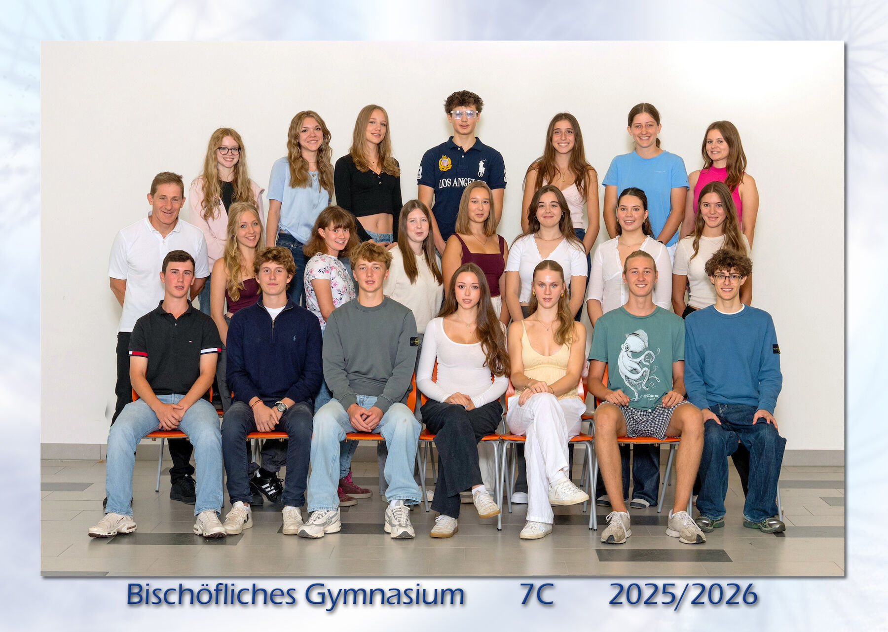 Eine Klasse von Schülerinnen und Schülern stellt sich für ein Gruppenfoto auf, in Reihen sitzend und stehend.