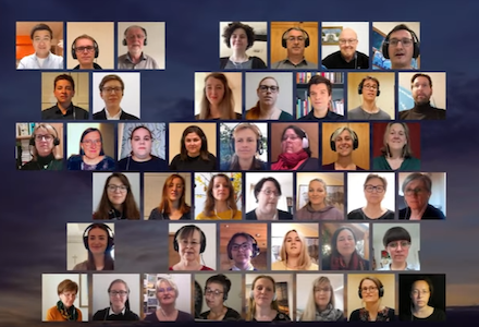 Ein virtueller Chor mit 35 Personen, die gemeinsam in einem Raster aus Videoanrufbildschirmen singen.