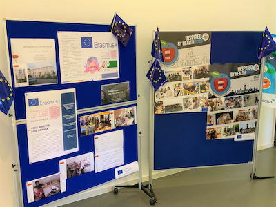 Zwei blaue Schautafeln mit Erasmus-Postern, Fotos und kleinen EU-Flaggen.
