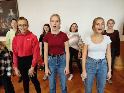 Eine Gruppe Jugendlicher, die in zwei Reihen stehend gemeinsam singen.