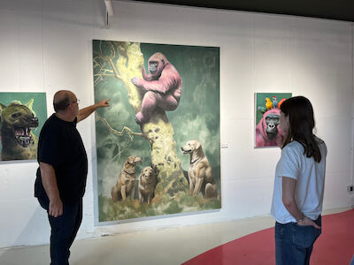 Zwei Personen betrachten Tiergemälde in einer Kunstgalerie, eine zeigt auf ein großes Kunstwerk.